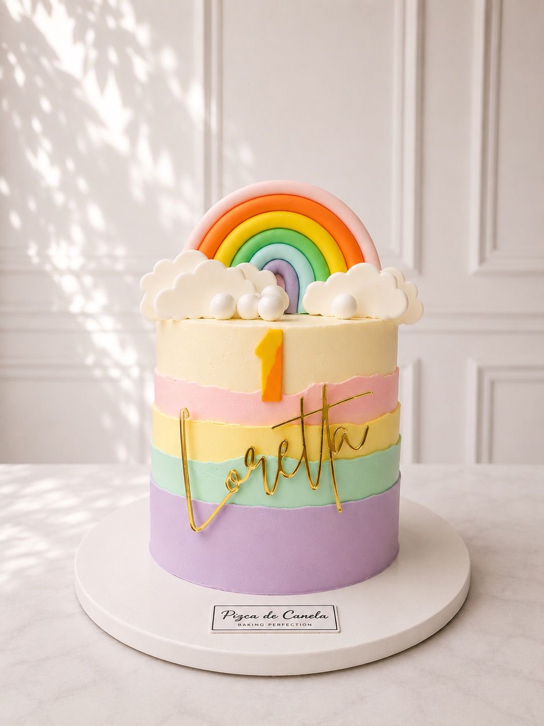 Pastel arcoíris pastel con topper dorado con nombre